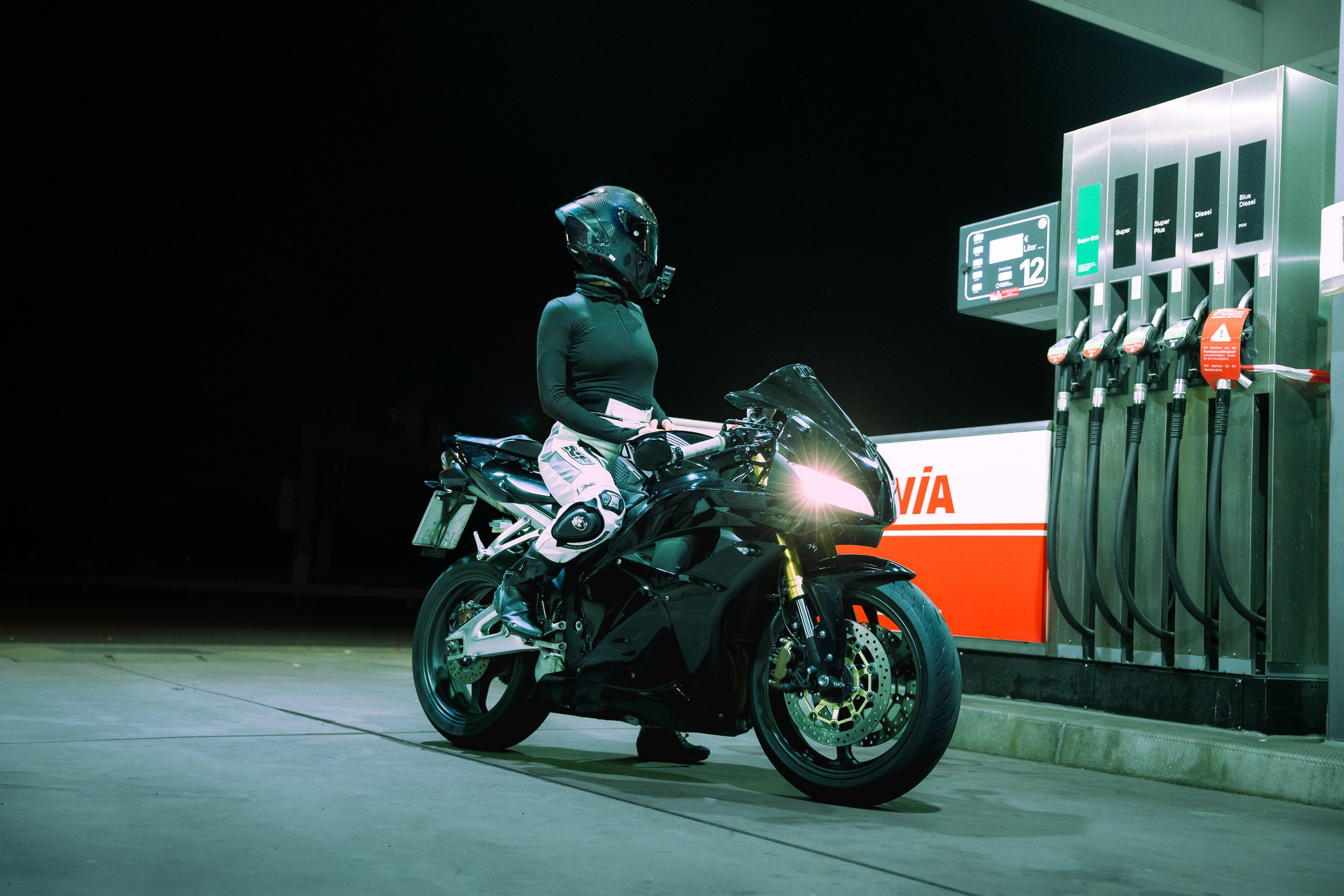 Motorradfahrer bei Nacht an einer Tankstelle