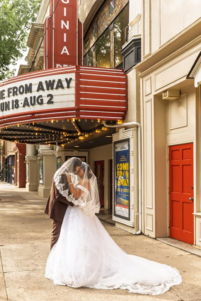 Khristy and Chris beneath a theater marquee on their wedding day in Richmond, Virginia.