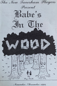 Cover of a play titled 'Babe's in the Woods' presented by The New Taverham Players, featuring a drawing of trees with smiling faces and a small figure in the woods, dated November/December 1996.
