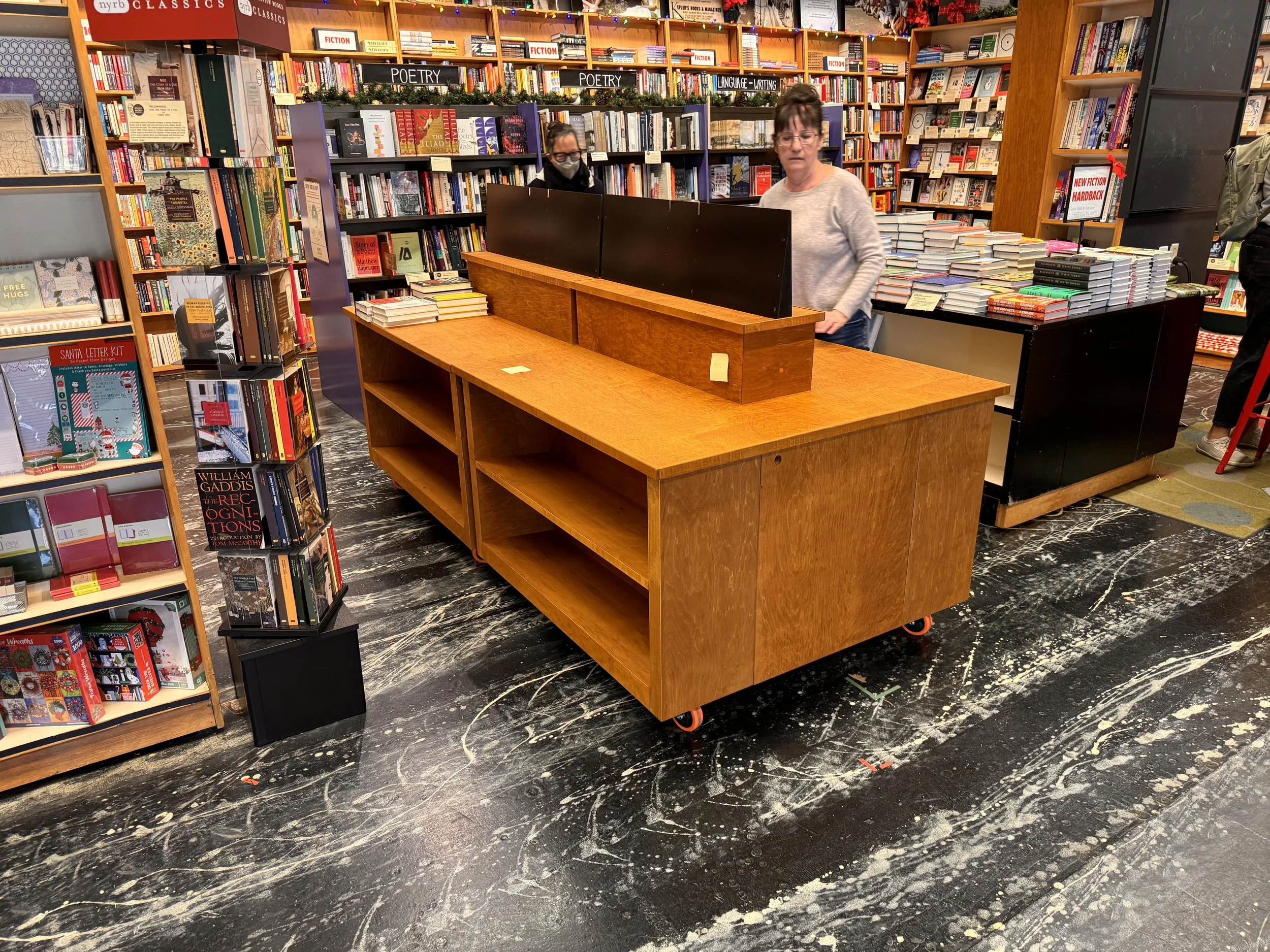 An empty wooden table designed for storing/displaying books.