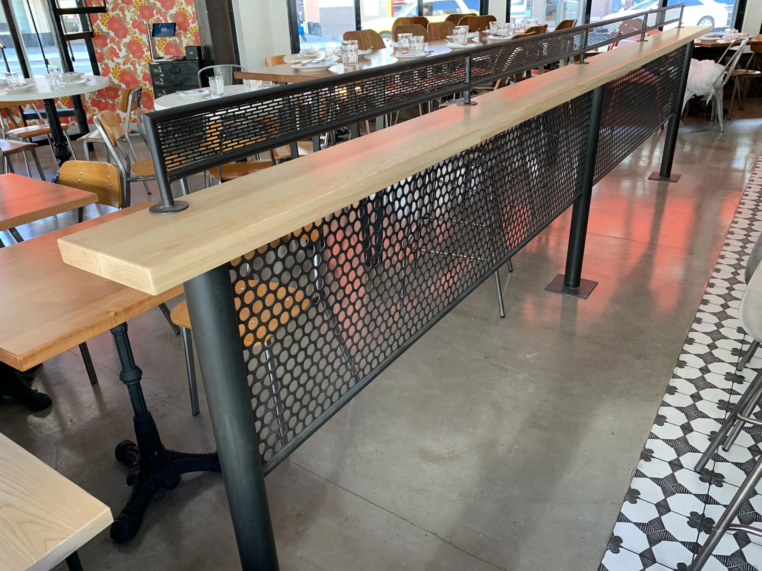 Metal and wood queue barrier to separate the seating area from the bar area.
