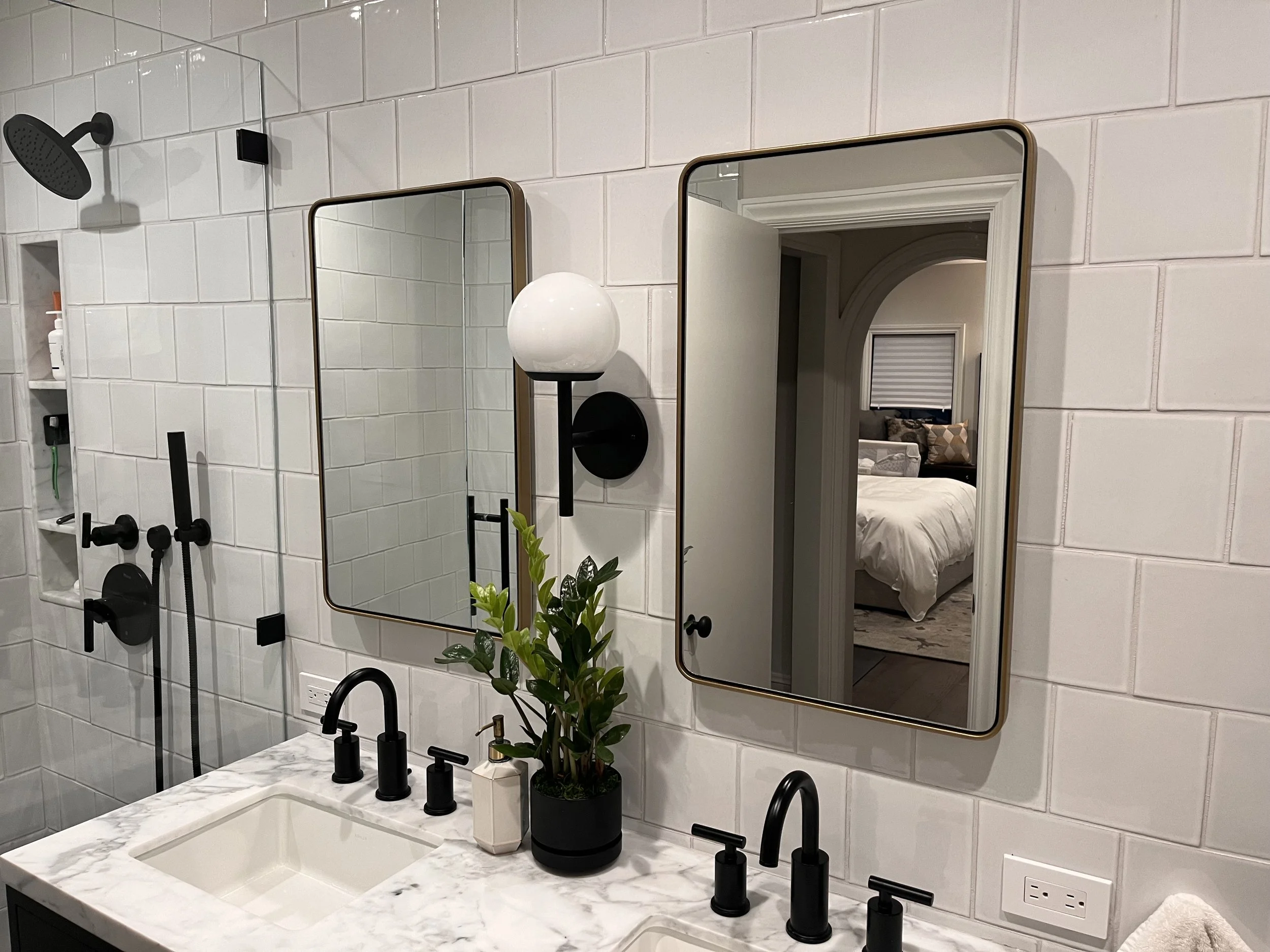 2 tall rectangular mirrors with smooth edges on the wall above the double sinks.