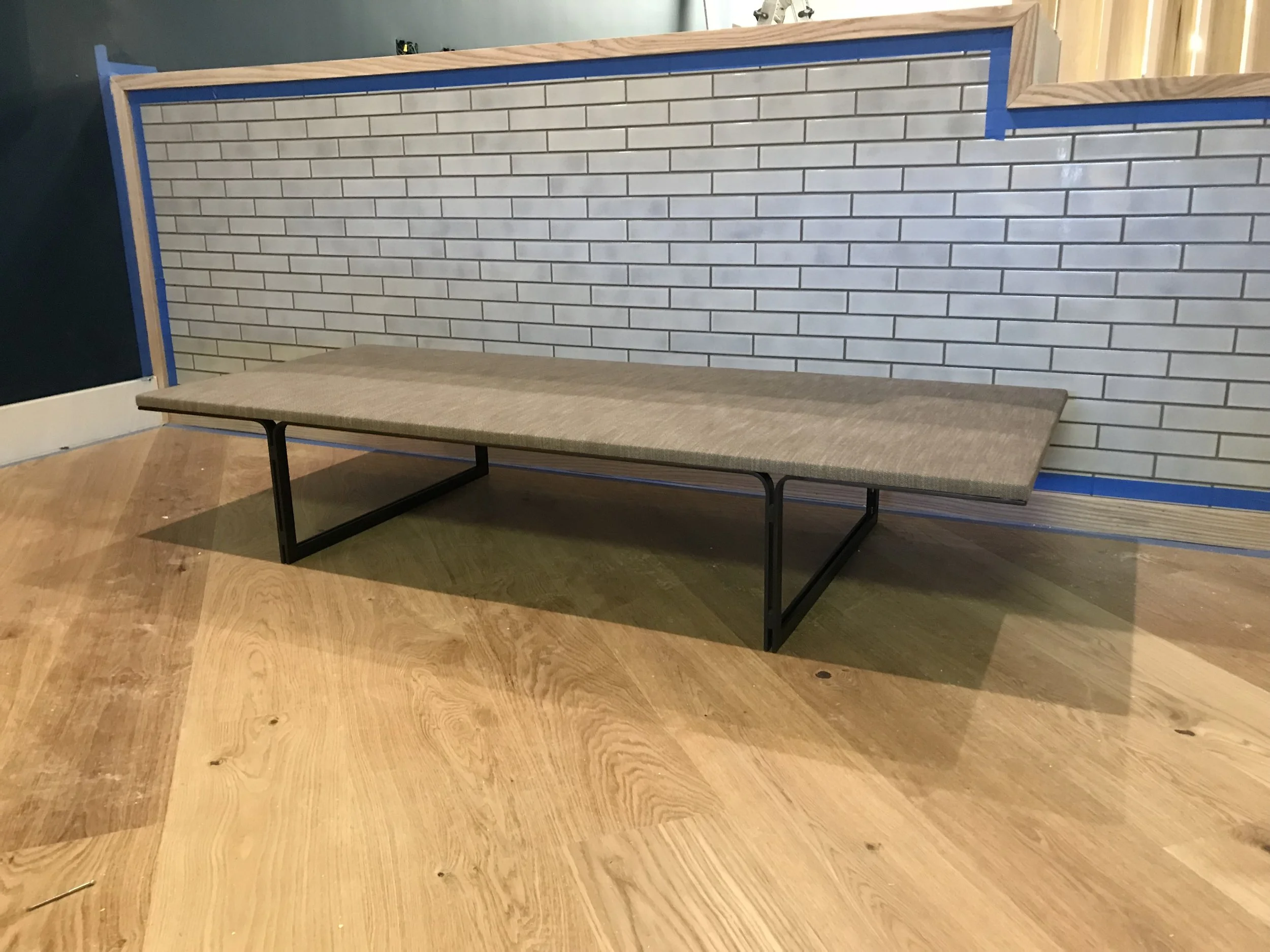 Custom made bench in front of a large counter with a grey brick like design.