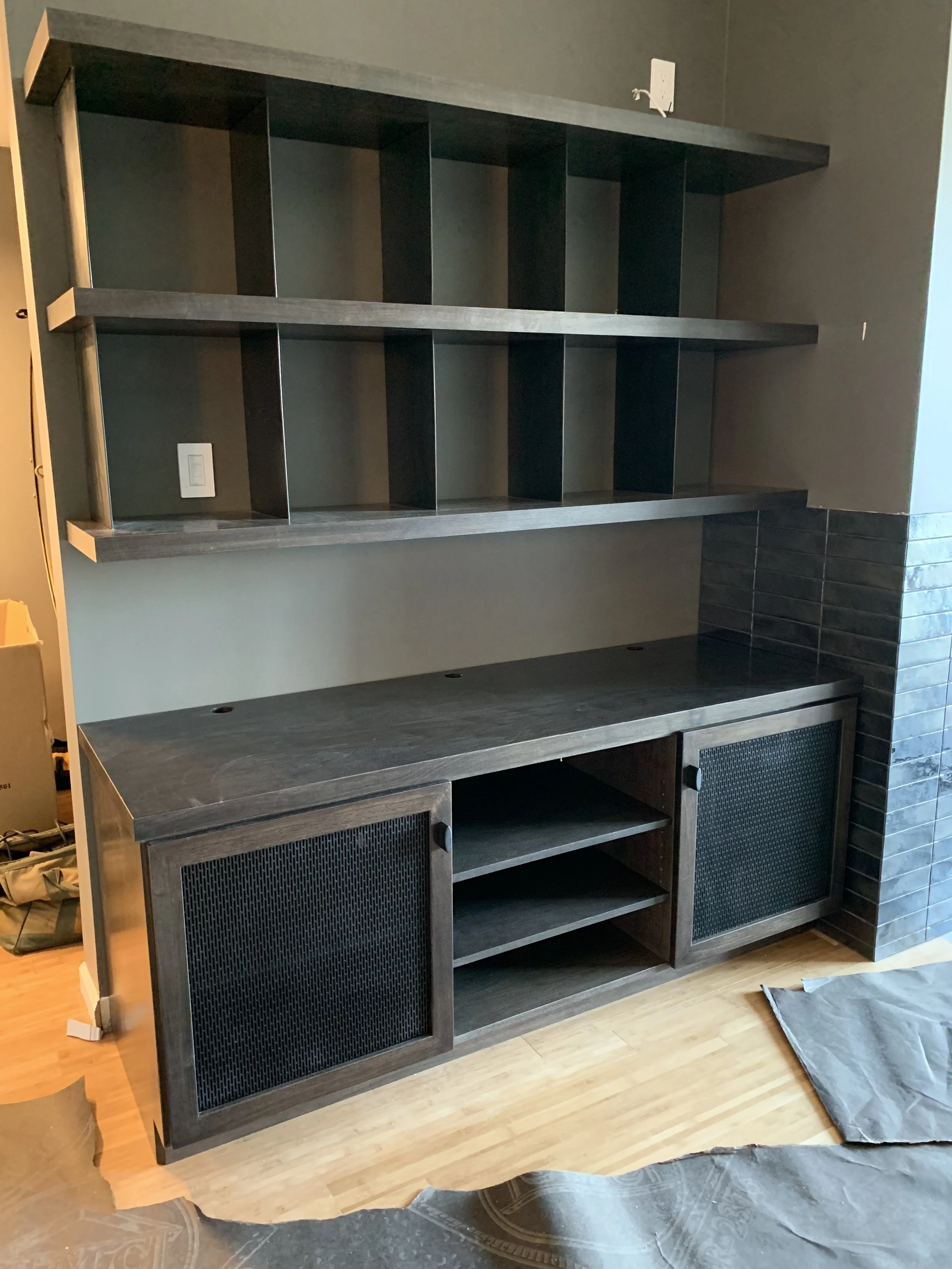 A matching wooden floor drawer and shelves are designed to fit in an awkward space of a residential house.