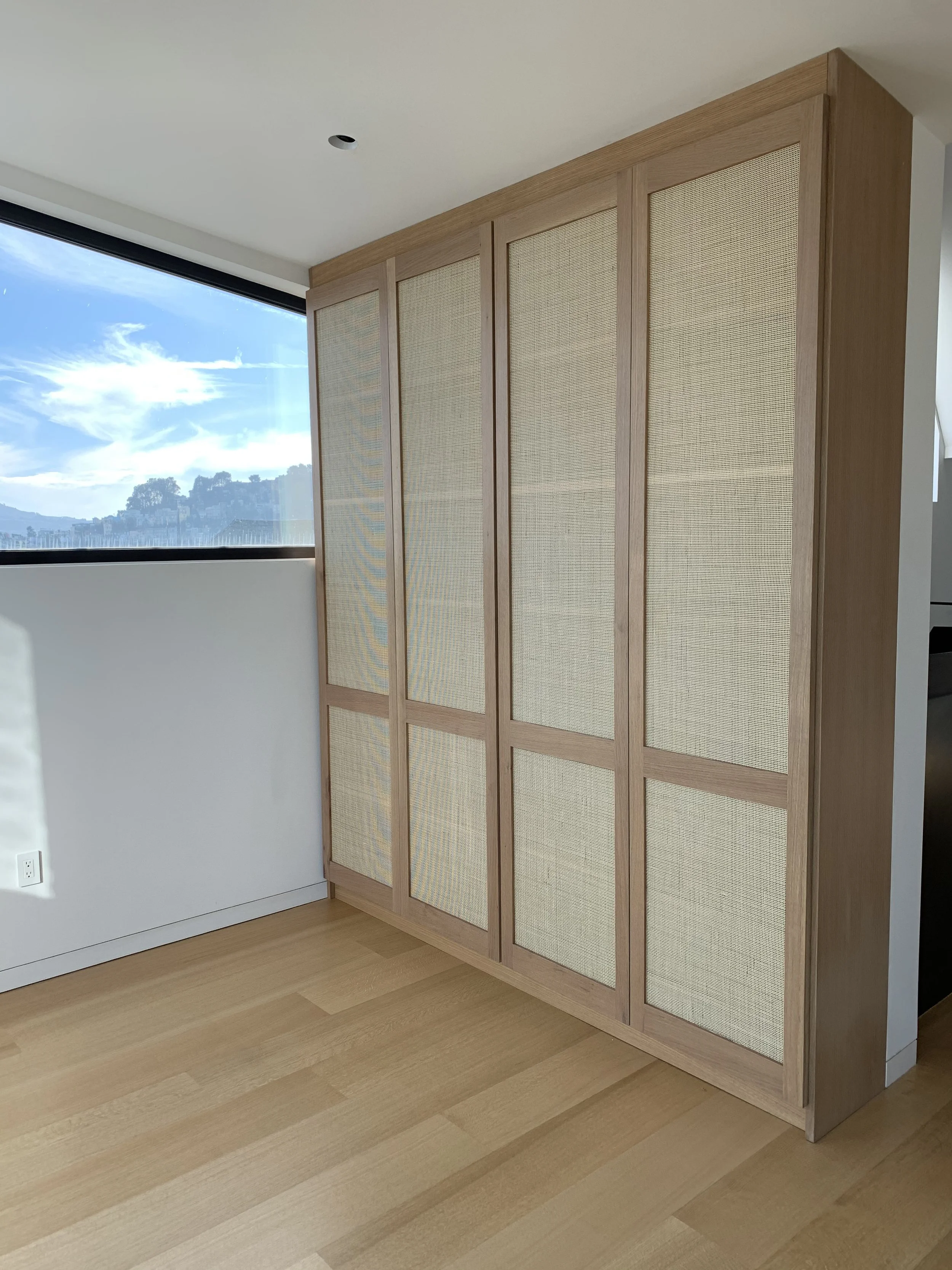 Wooden cupboard with a cross like design on the doors. The space in-between the cross shape is made of fabric.