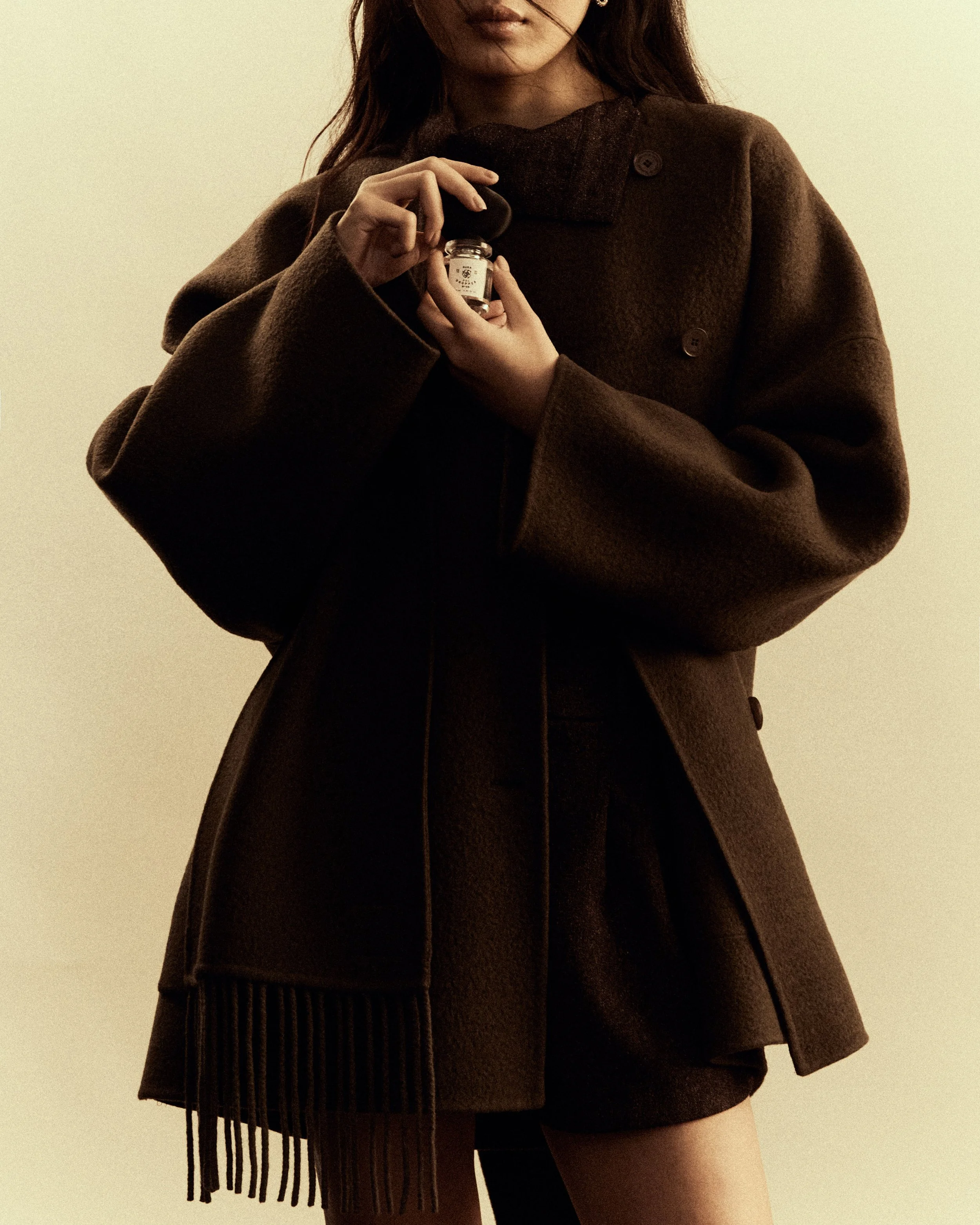 Donna in abbigliamento scuro che tiene una pillola in una confezione.