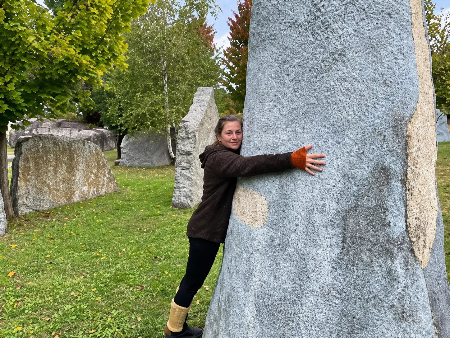 Frau im Skulpturenpark des Kunstmuseums Waldviertel an einer großen Granitskulptur