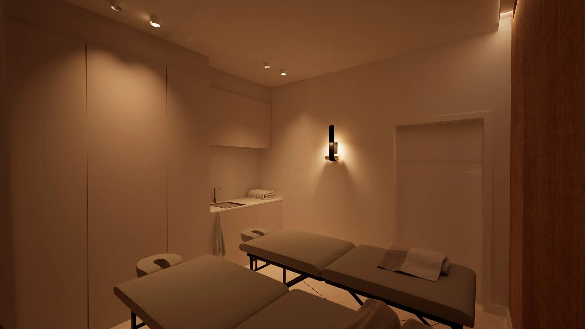Salle de massage minimaliste avec deux tables de massage, un lavabo, des serviettes, et un éclairage doux