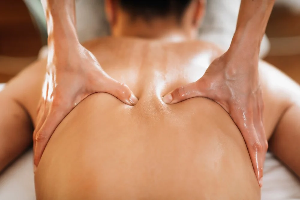 Une personne reçoit un massage à la colonne vertébrale sur une table de massage.