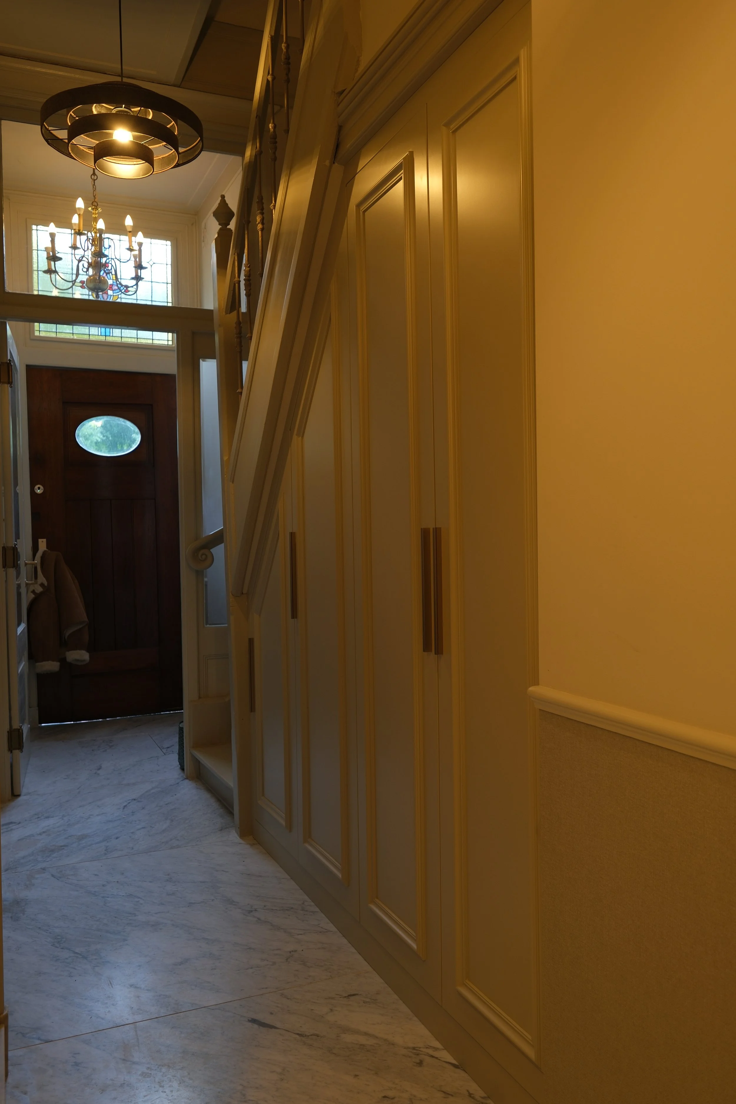 Gang met lichte paneelkasten en marmeren vloer in herenhuis in Leiden – KragtenStudio