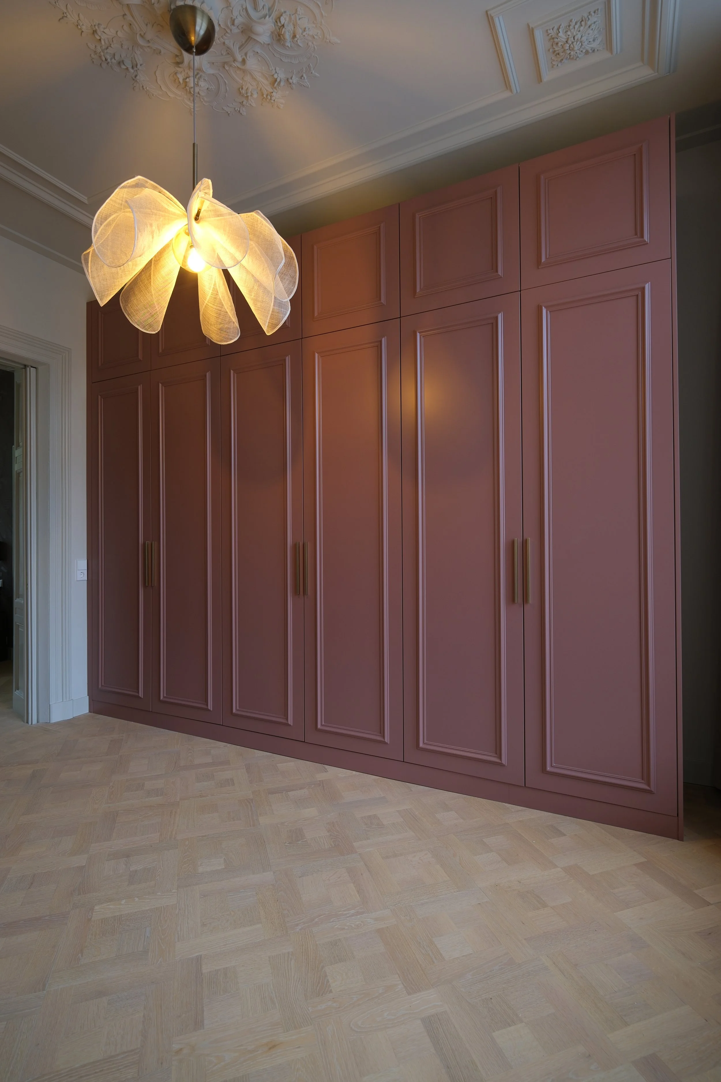 Oudroze kastenwand onder een klassiek ornamentplafond – KragtenStudio
