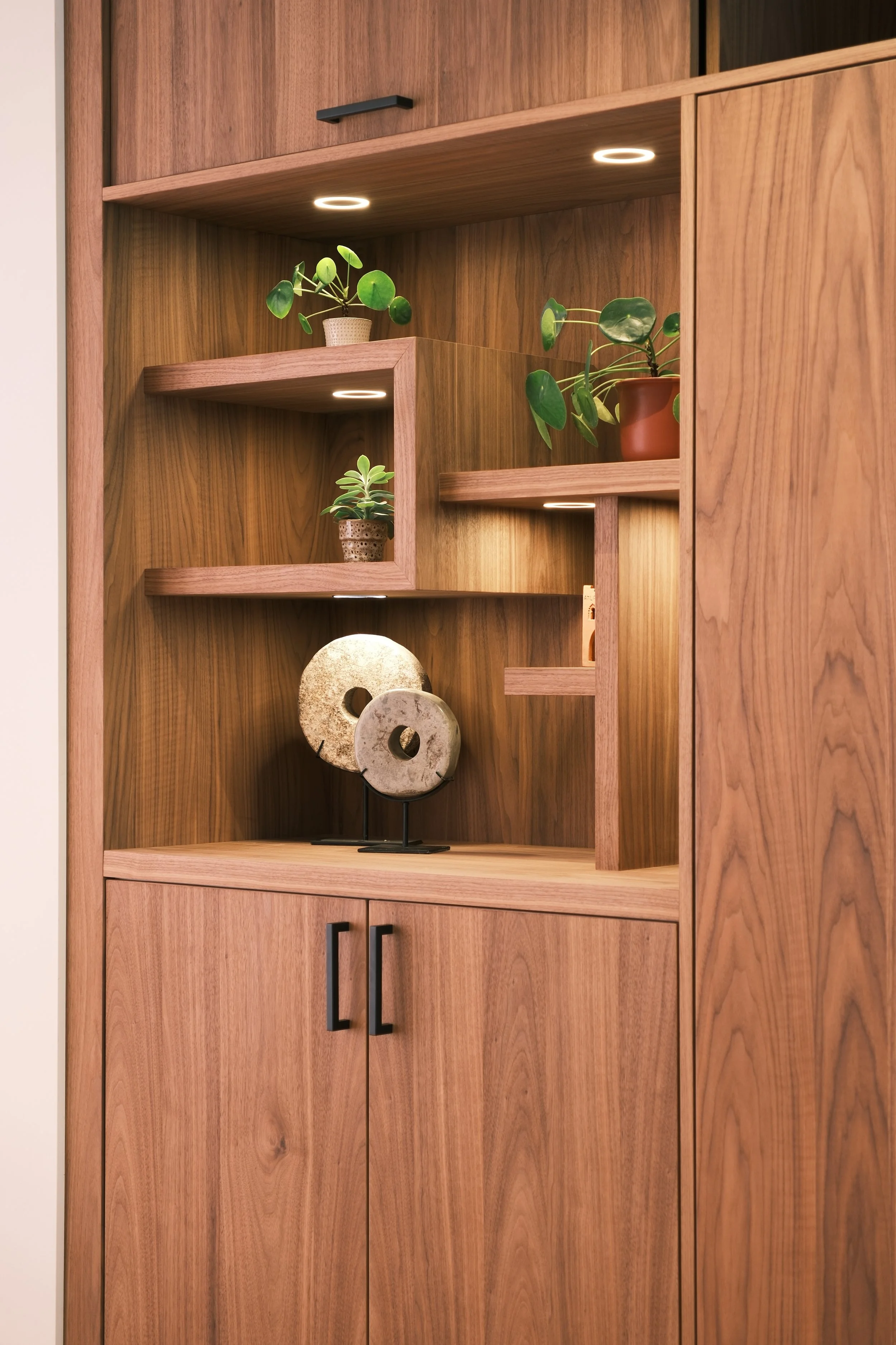 Detail van de verlichte vakkenkast in notenhout fineer – KragtenStudio