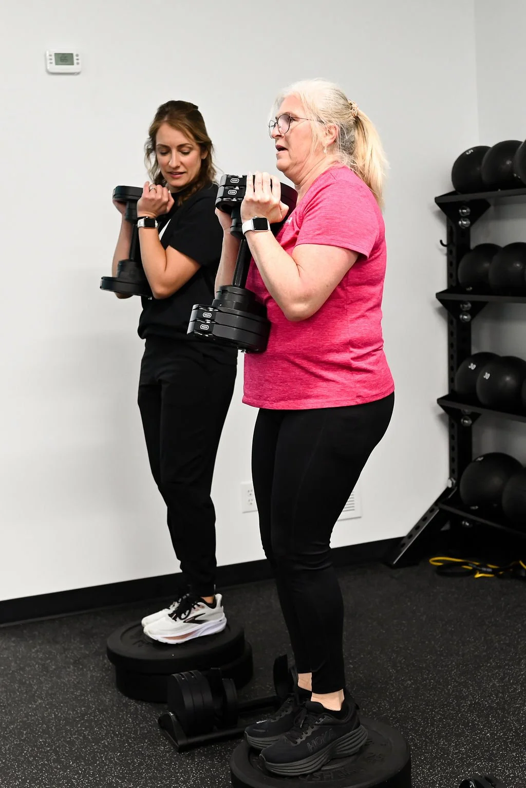 Woman that's 60+ working with a physical therapist during a session at Hyphen fitness & physical therapy in Georgetown, KY. She's working to overcome osteoporosis.