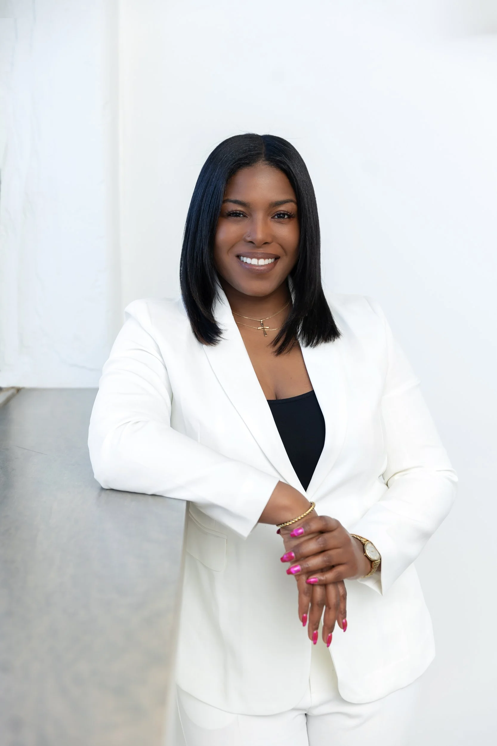 Marketing strategist Tatiana Jackson standing with hands folded with elbow on window seal smiling