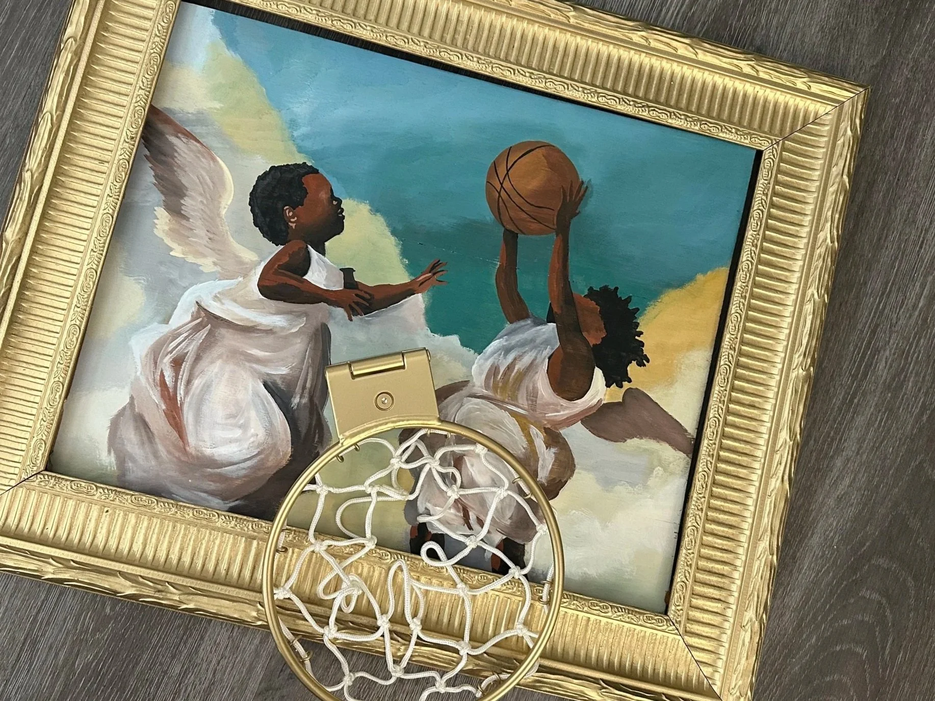 Painting of two children playing basketball, one child is aiming to shoot while the other reaches out to block the shot, framed in a gold ornate frame, with a basketball hoop in the foreground.