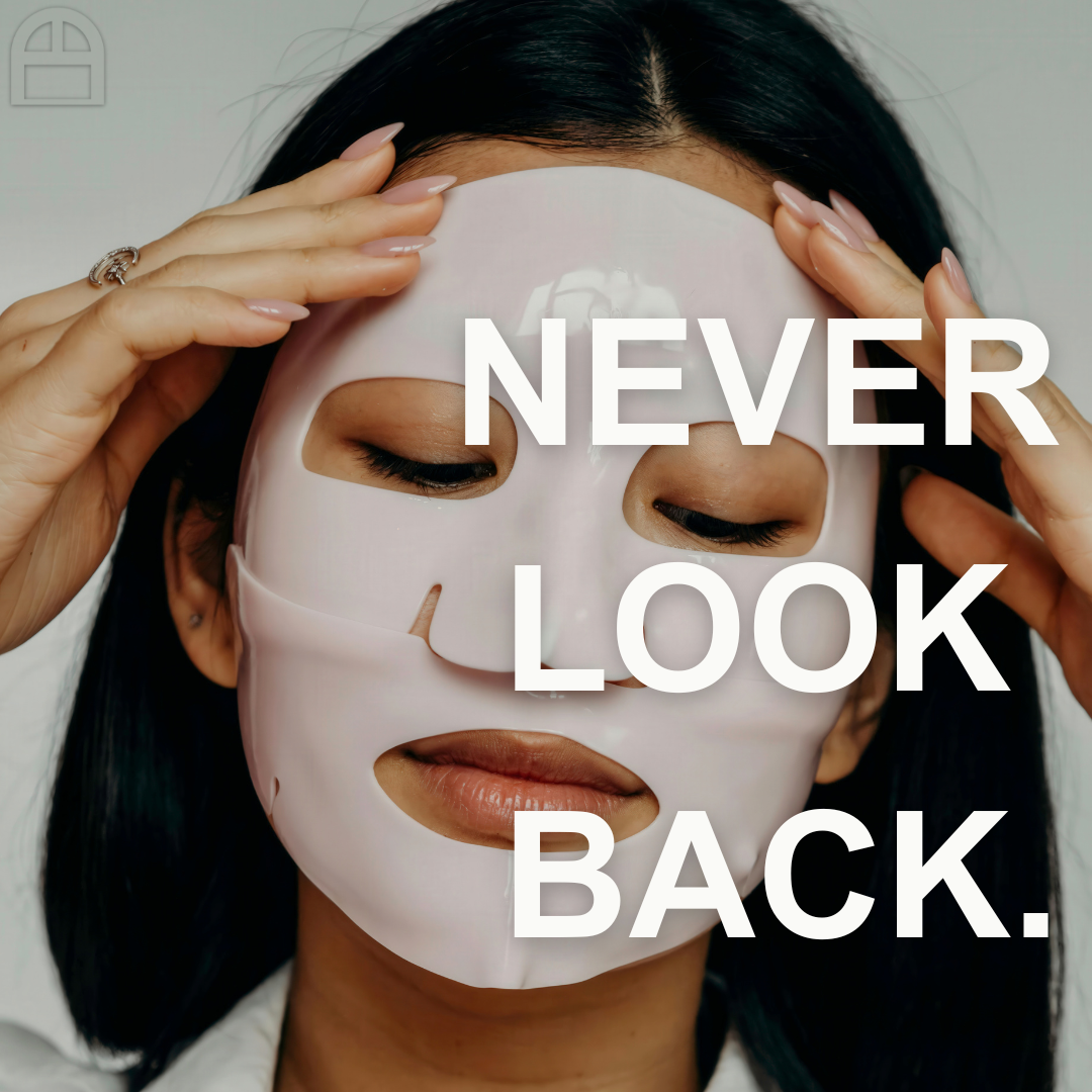 A woman with dark hair wearing a white facial sheet mask, gently touching her face with her hands. The text 'NEVER LOOK BACK.' is overlaid on the image.