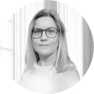 Black and white portrait of a woman with shoulder-length hair wearing glasses.