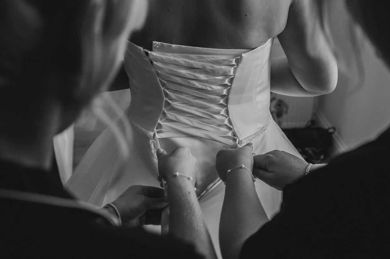 Brides-dress-being-tied-black-and-white