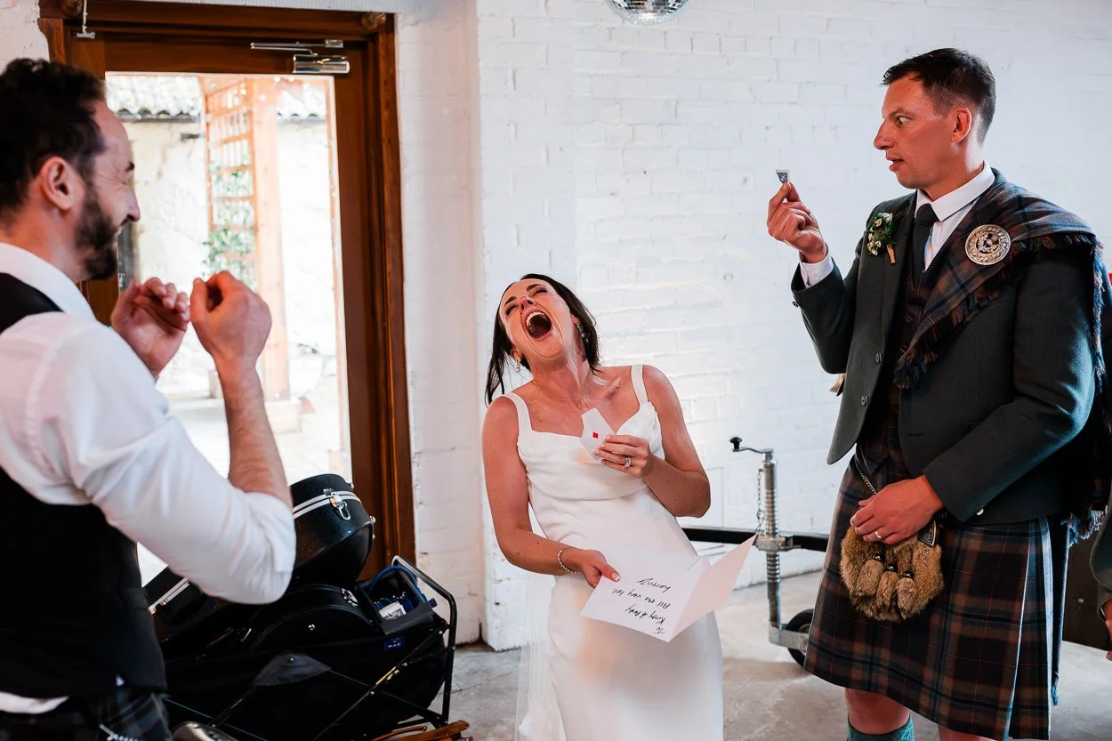 Bride-and-groom-laughing-hysterically-watching-magic-trick-cardney