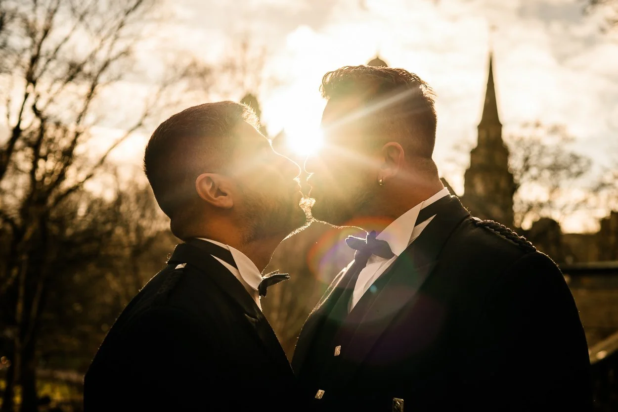 silhouette of two grooms with Edinburgh skyline behind