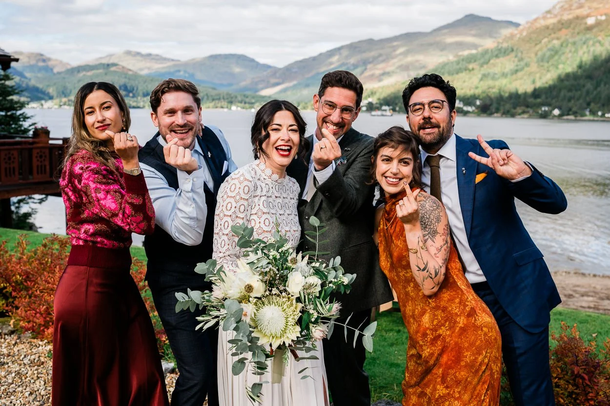 Group-picture-of-friends-at-wedding-with-loch-goil-behind