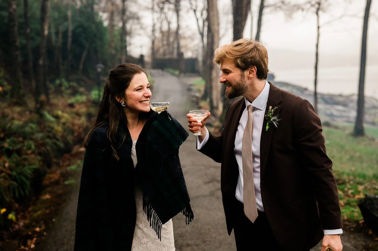 Bride and groom toasting whilst walking down country path