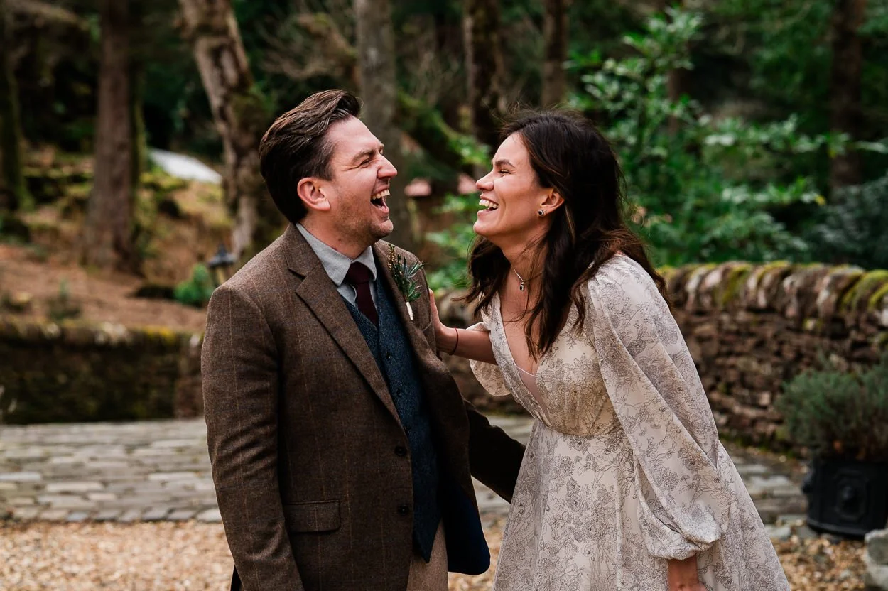 Bride and groom looking at each other and laughing hysterically 