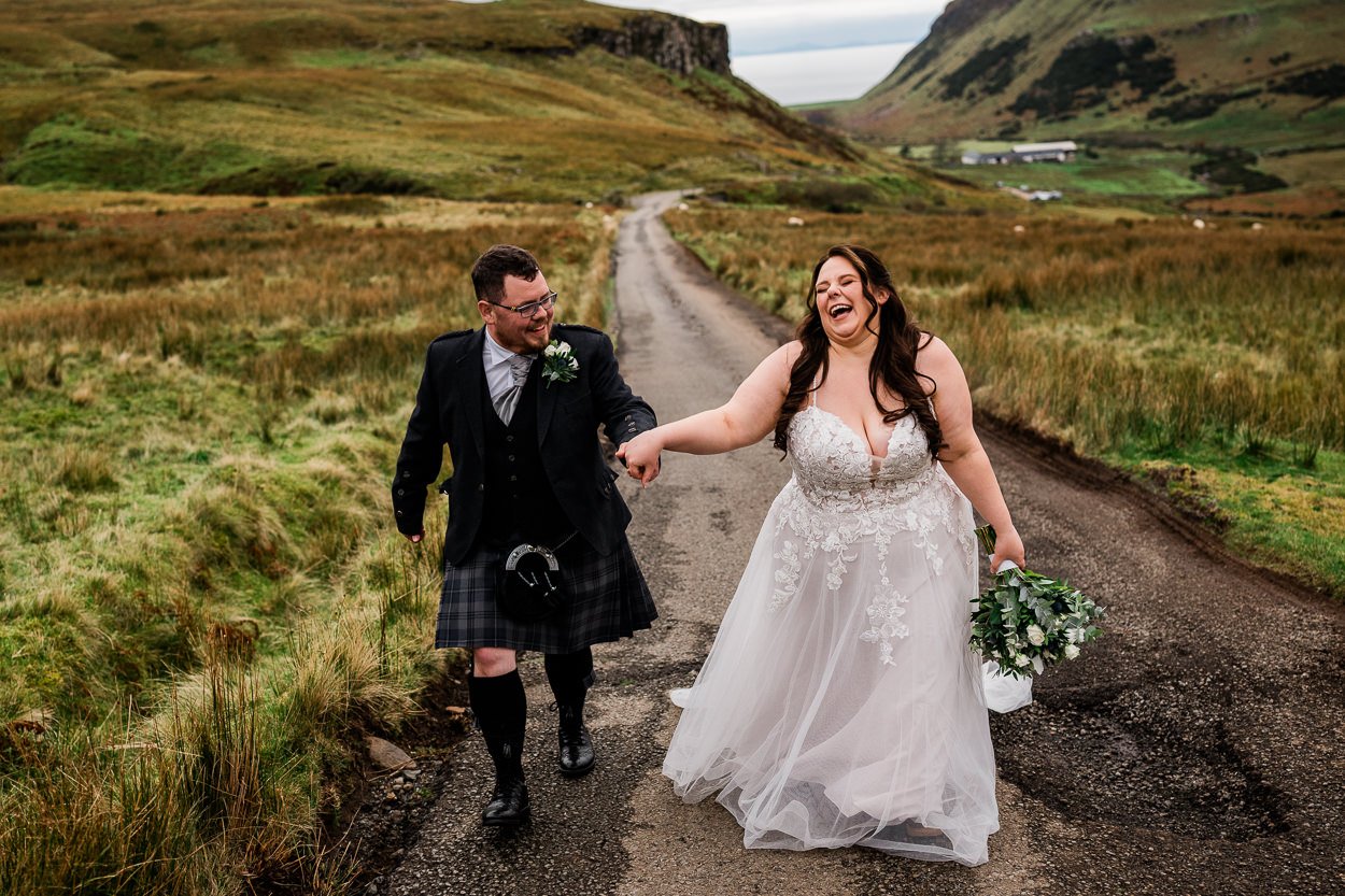 Bride-and-groom-laughing-whilst-walking-on-road-to-Talkisker-Bay