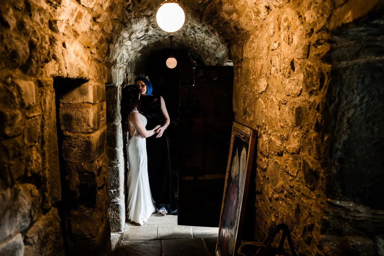 Two brides kissing with lovely light in Kilmartin Castle