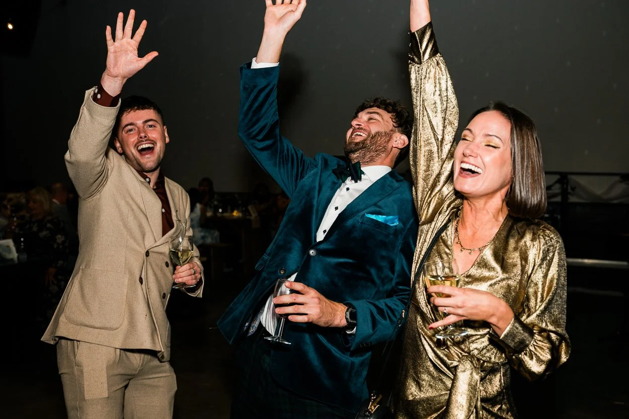 Guest reaching for the sky on the dance floor at wedding