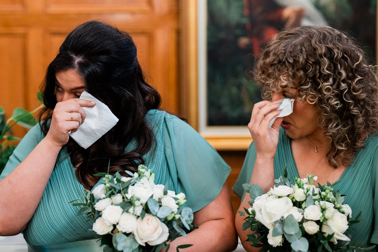 Two bridesmaid crying in sync at wedding