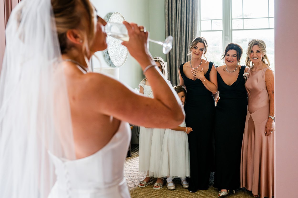 Bride-drinking-wine-during-first-look-before-wedding