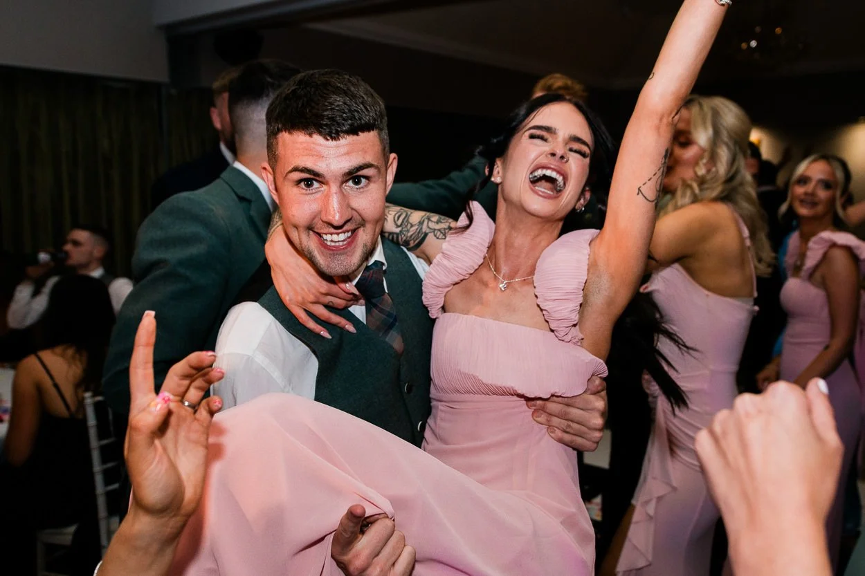 Bridesmaid-being-lifted-and-screaming-on-dance-floor