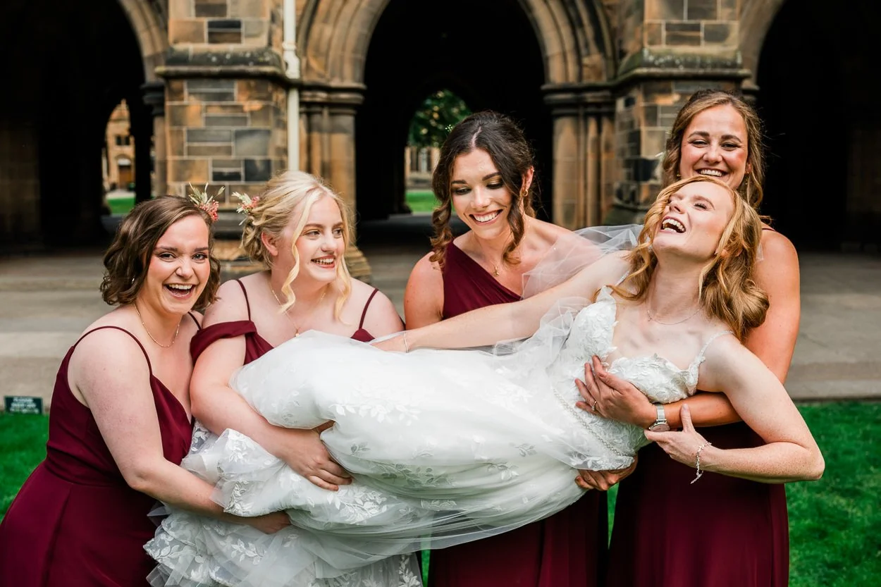 Bridesmaids lifting bride up for a fun picture
