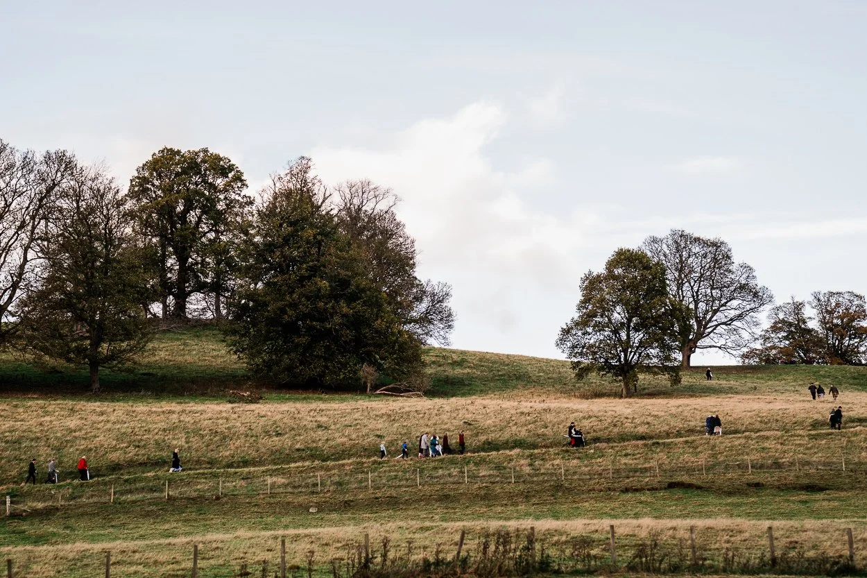 Guests hiking up hill to wedding ceremony at Byre at Inchyra