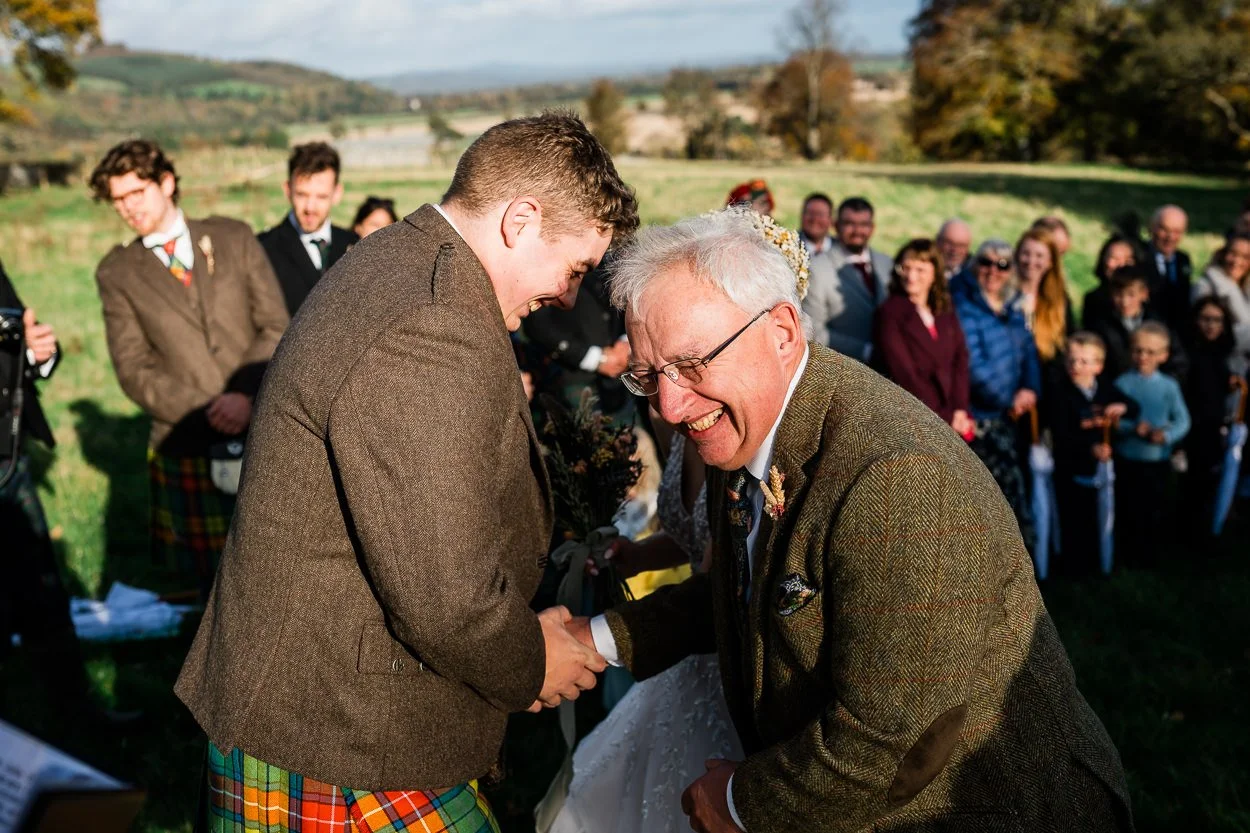 Groom and father of the bride laughing