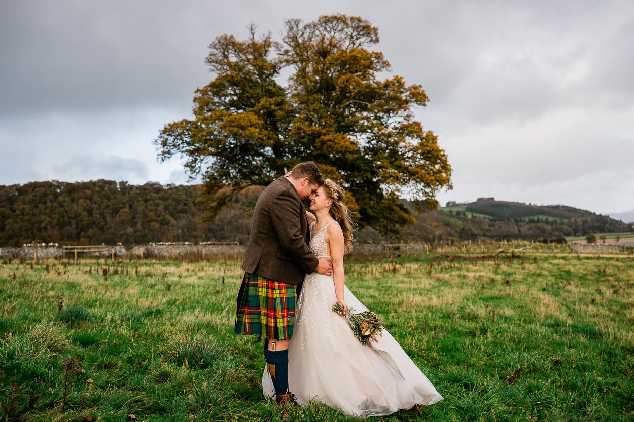 Bride and groom portrait on a hill overlooking Byre at Inchyra