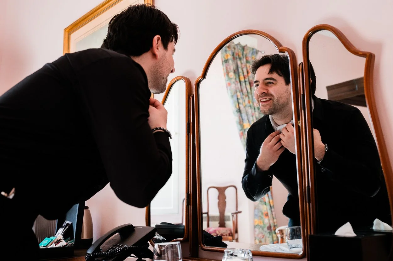 Groom looking in the mirror at Dalhousie Castle