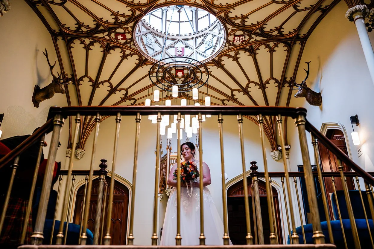Bride walking through grand hall at Dalhousie Castle
