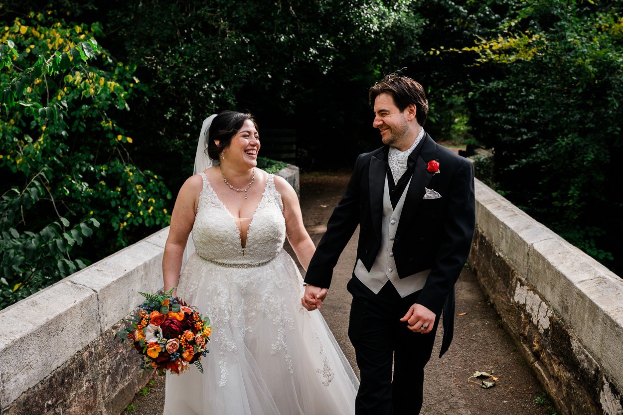 Bride and groom holding hands laughing 