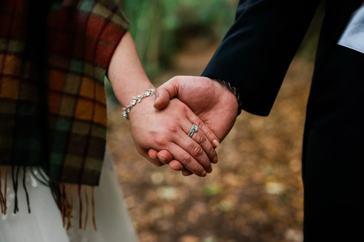 Holding hands wedding rings shot