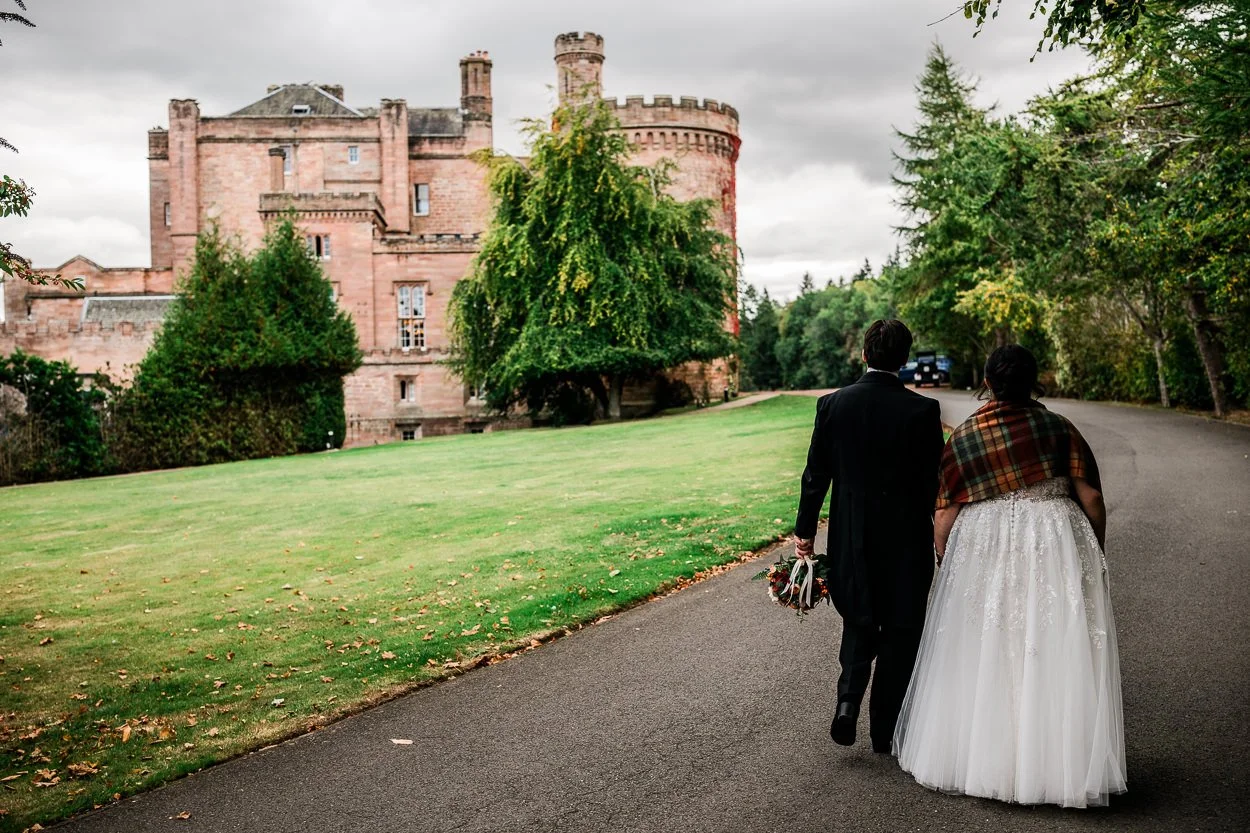 Bride and groom walking towards Dalhousie Castle