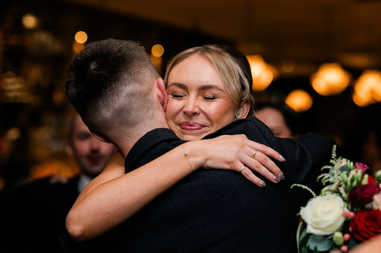 Candid photography of emotional hug at wedding