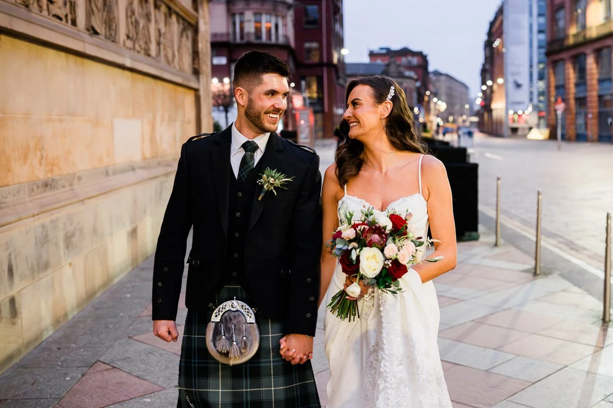 Bride and groom walking down the street laughing