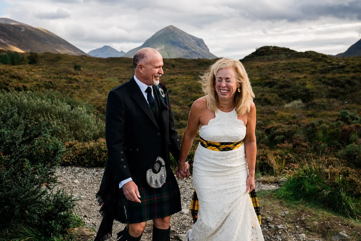 Isle of Skye elopement bride and groom laughing whilst walking in wilderness
