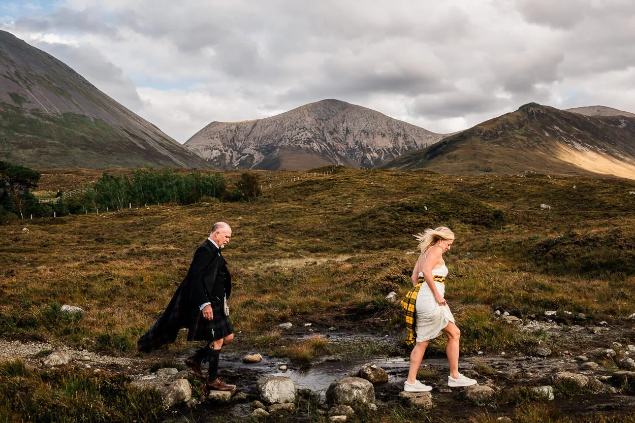 Bride and Groom walking over stepping stones during Isle of Skye elopement