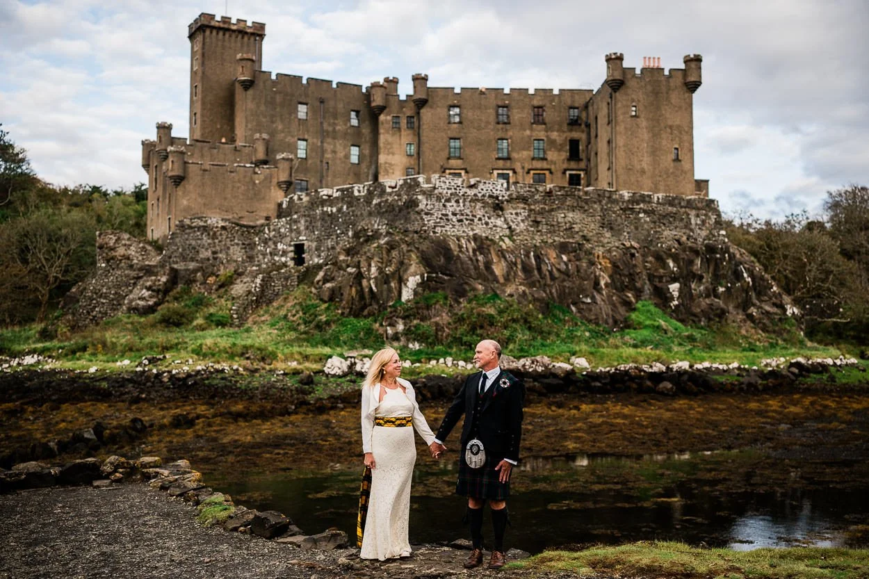 Bride and groom standing in front of Dunvegan Castle, Skye