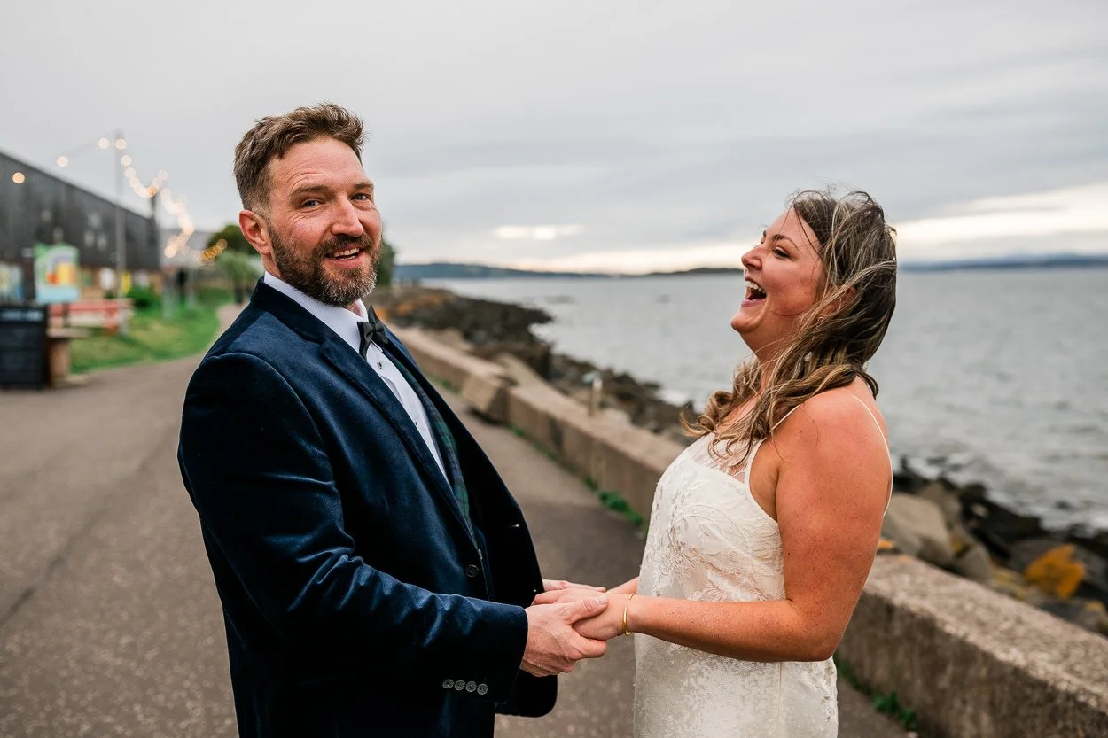 Bride and Groom laughing on Leith beach