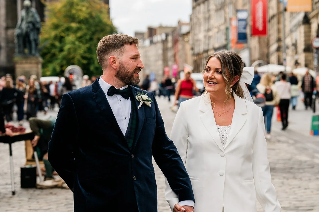 Bride and groom walking down the royal mile Edinburgh