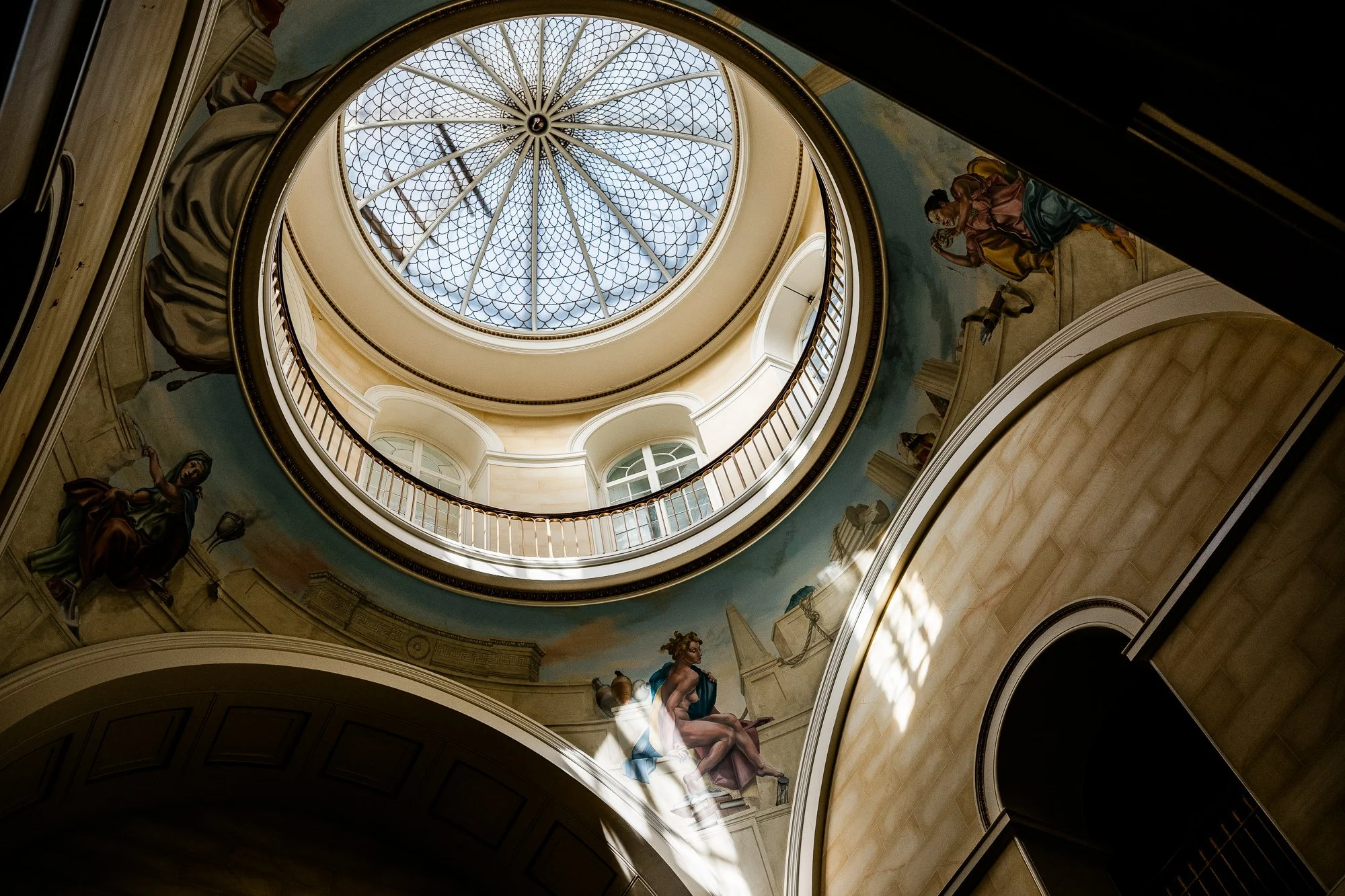 Looking up the sweeping stone staircase towards the circular skylight inside Kinmount House.